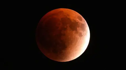 : A red full moon, also known as a blood moon, is seen during a lunar eclipse in Sinop, Turkye, on September 7, 2025