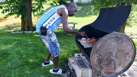 A man uses a grill to make food