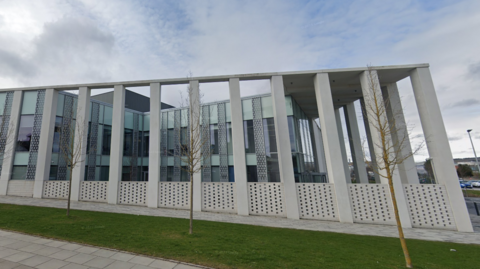 The grey exterior of Inverness Justice Centre. The outside of the building features a number of pillars.