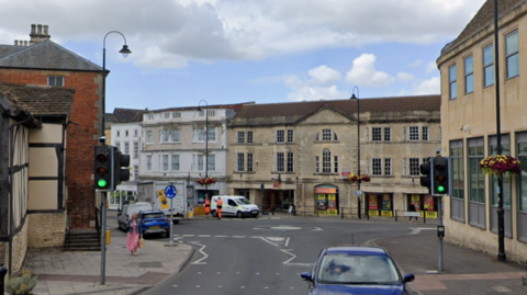 Traffic lights crossing Market Place. A roundabout sits just behind it in view.