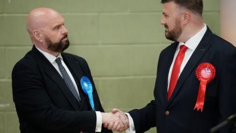 Labour candidate Chris Webb shakes hands with Conservative candidate David Jones after winning the Blackpool South by-election