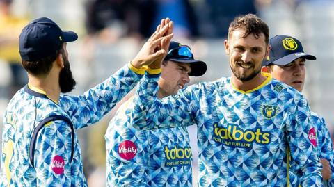Ed Barnard high fives his team-mate Moeen Ali after taking a wicket for Bears