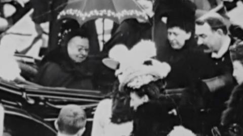 Queen Victoria in a carriage, surrounded by crowds