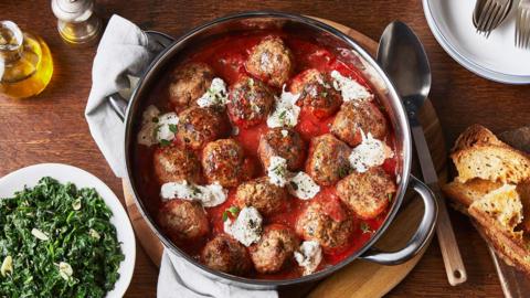 Meatballs in tomato sauce with burrata and crostini.