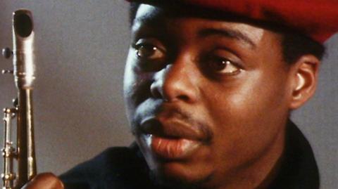 Close up of musician Courtney Pine holding a saxophone.