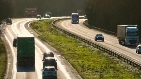 A general view of the A14 carriageway close to Ipswich on a sunny day. The photo has been taken from a bridge above the carriageway. Vehicles can be seen travelling along each side of the road.