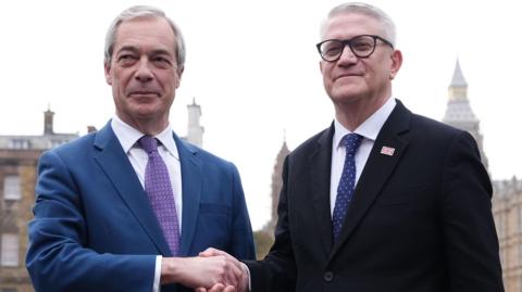 Reform UK leader Nigel Farage and Andrew Rosindell shaking hands on College Green in Westminster, central London.