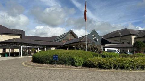 The front entrance to Noble's Hospital has a paved road around it.