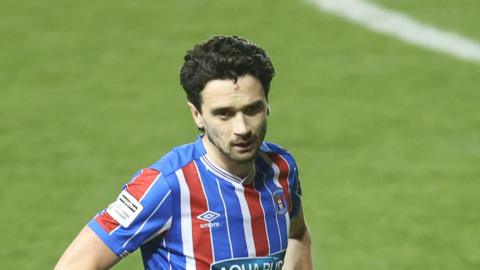 Carlisle player Alex Gilliead stands with his hands on his hips during a match