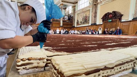 Female chef in whites piping the record-breaking tiramisu