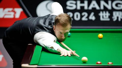 Judd Trump plays a shot