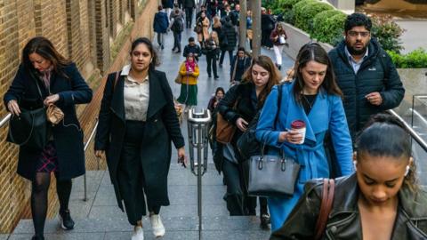 Commuters make their way up a set of stone stairs as they walk to work from Liverpool Street train station during the morning rush hour in the City of London, UK, on 16 April 2024. 