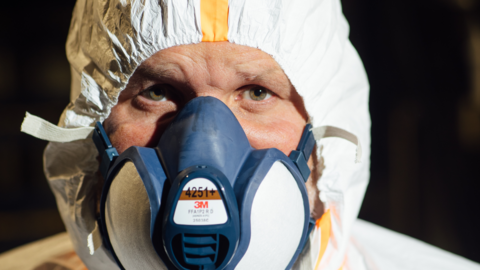 Close image of Ben Giles' face, he is wearing a face mask and white forensic suit