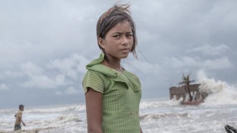 A girl stands in front of her tea shop, which has been destroyed by the sea during a storm, in Frazerganj, Sundarbans, India