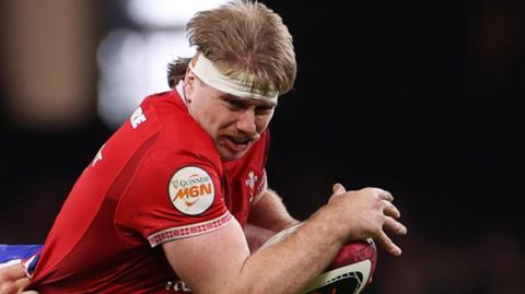 Aaron Wainwright with the ball tries to break a French tackle
