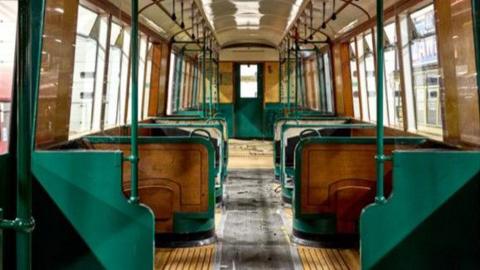 Inside one of the Q stock carriages - there are wooden floors as well as  are green poles and edges