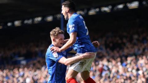 Portsmouth's Terry Devlin jumping into the arms of team-mate Regan Poole in celebration