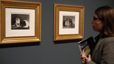 Woman looks at Man Ray's photographs Noire et Blanche at The Radical Eye exhibition