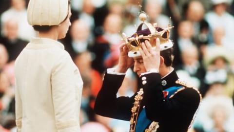 Prince Charles is given the gold coronet of the Prince of Wales by his mother Queen Elizabeth