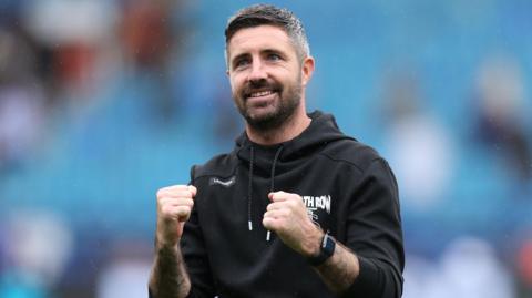 Swansea City head coach Alan Sheehan pumps his fists at the crowd