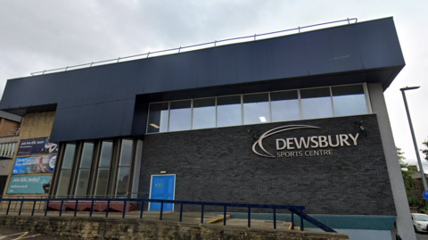 An external view of Dewsbury Sports Centre, with its name in large letters on the side of the building