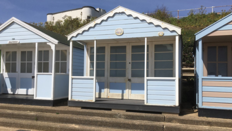 Three blue beach huts in a row