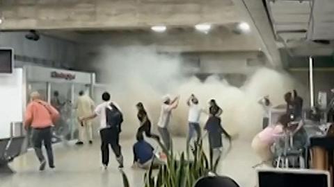 People fleeing in airport as dustclouds fall from ceiling
