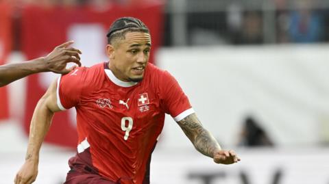 Austria's Kevin Danso and Switzerland's Noah Okafor pictured during a friendly in June 2024