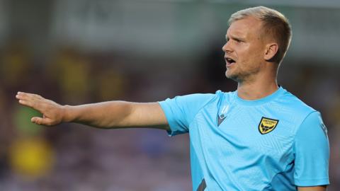 Oxford United boss Liam Manning directs his players from the touchline during a League One match.