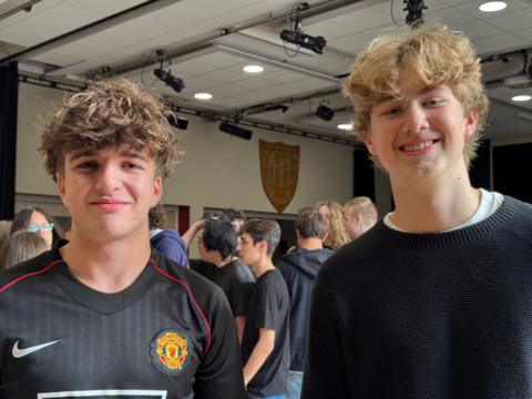 Two boys, one has curly brown hair and one has curly blonde hair.