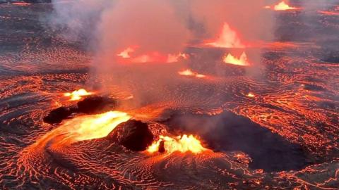 Lava flowing on the Halema'uma'u crater floor alongside several active vent.