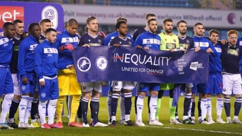 Millwall and QPR players holding an anti-racism banner before their game on 8 December 2020