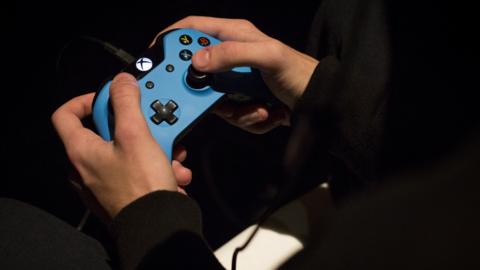 Close up of hands on an xbox controller