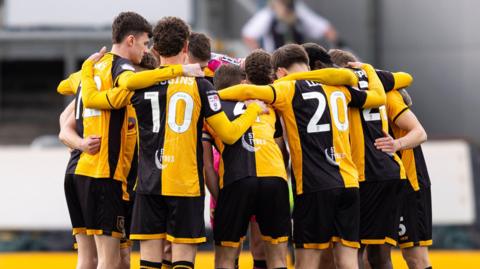 Newport County squad in a huddle before the game