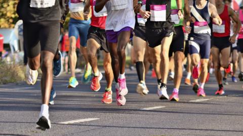 The legs of people running in a line