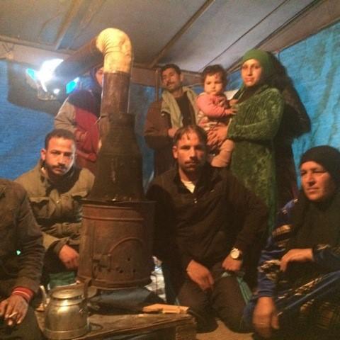 A family huddles inside a tent in the Torbuli refugee camp