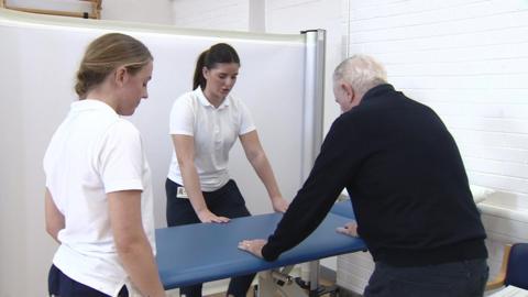 Physios helping a patient