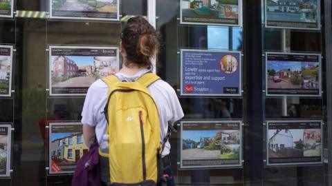 Woman looking at estate agents window