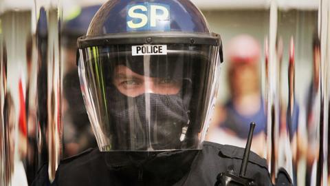 Police officer in riot helmet