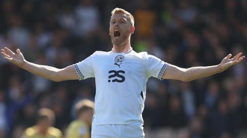 Jayden Stockley throws his arms out and appeals during a match for Port Vale
