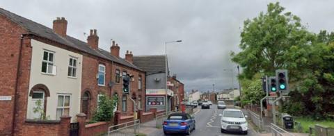 A screenshot from Google of a main street with around 5 cars driving on it. 