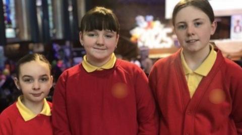 (Left to right) Scarlet; Ava and Rebecca are in their red and yellow school uniforms