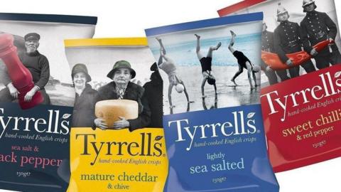 Four bags of Tyrrells crisps - one black, one yellow, one blue and one red.