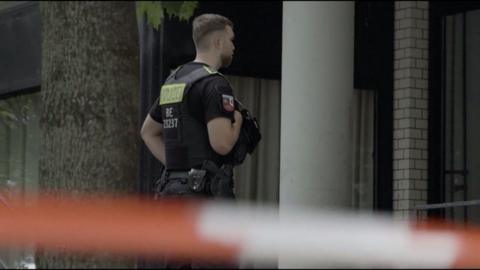 German police officer standing guard in front of police tape