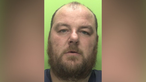 A mug shot of Callum Knott with a green background