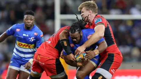 Joseph Dweba of DHL Stormers tackled by Taulupe Faletau and Josh McNally of Cardiff