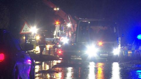 Lorry being removed from water by crane