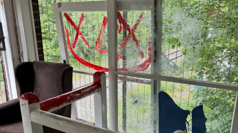 Smashed windows spray painted with red 