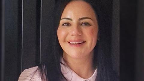Vikki Soloman. She is wearing a pink top and is smiling at the camera. 