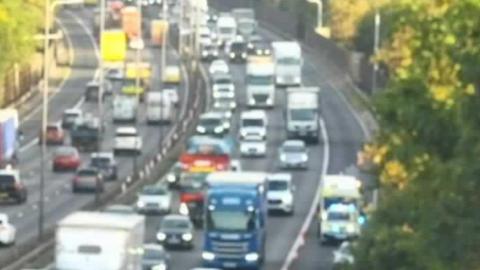 Plenty of traffic across three lanes of the motorway northbound and also southbound.